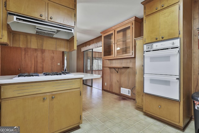 kitchen featuring wooden walls and white appliances