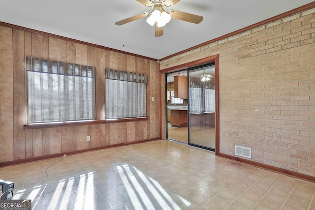 spare room featuring brick wall, wood walls, and ornamental molding