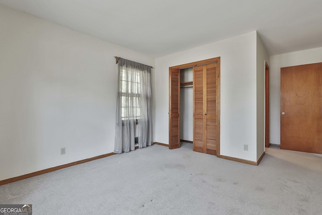 unfurnished bedroom with a closet and light colored carpet