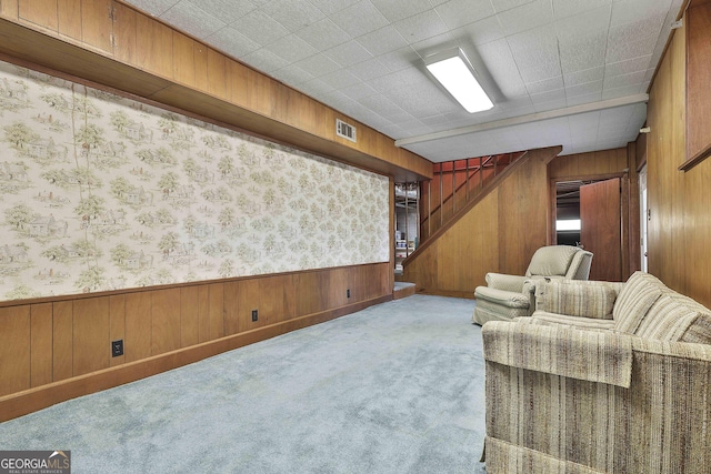 living room with light carpet and wood walls