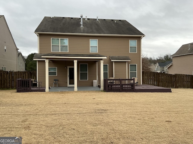 back of house featuring a lawn, a deck, and a patio area