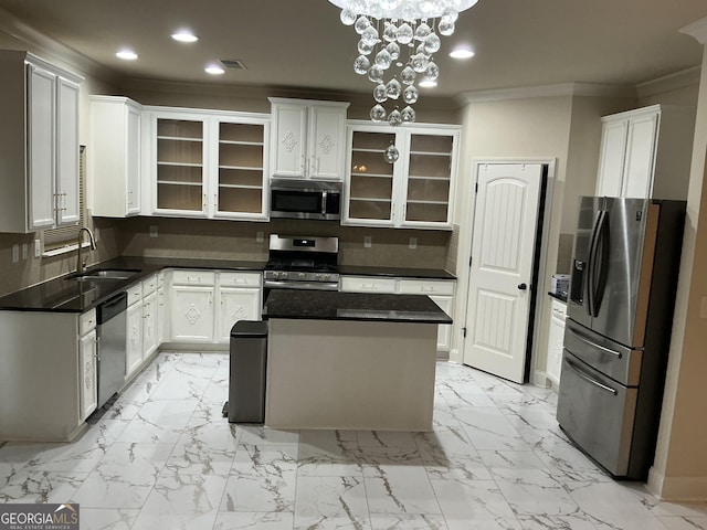 kitchen featuring stainless steel appliances, white cabinets, a kitchen island, and sink