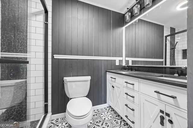 bathroom with a shower with shower door, toilet, vanity, and ornamental molding