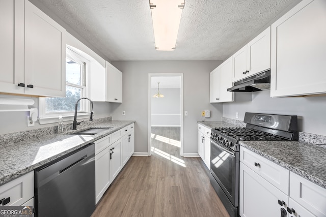 kitchen featuring range with gas cooktop, dishwasher, white cabinetry, light hardwood / wood-style floors, and sink