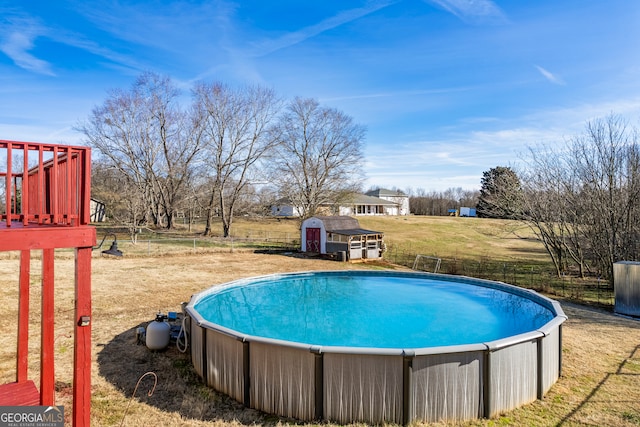 view of pool with a storage unit and a yard