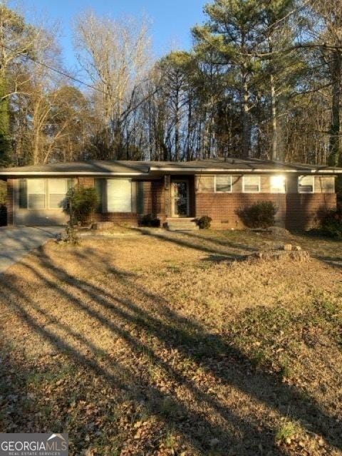 single story home featuring a garage, a front yard, and a carport