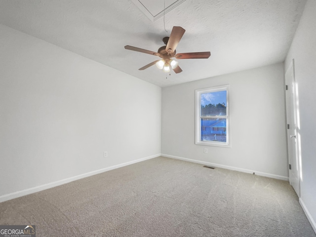 carpeted empty room featuring ceiling fan and a textured ceiling