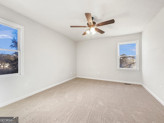 carpeted spare room with ceiling fan