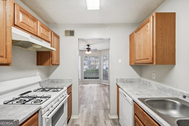 kitchen featuring ceiling fan, white appliances, a textured ceiling, light hardwood / wood-style flooring, and sink