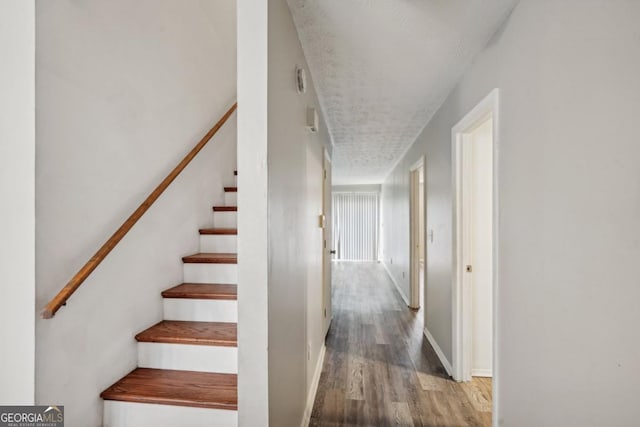 staircase featuring hardwood / wood-style flooring and a textured ceiling