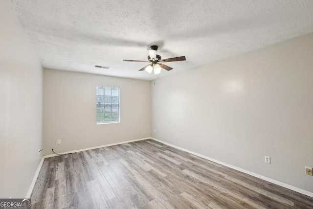 unfurnished room featuring wood-type flooring and a textured ceiling