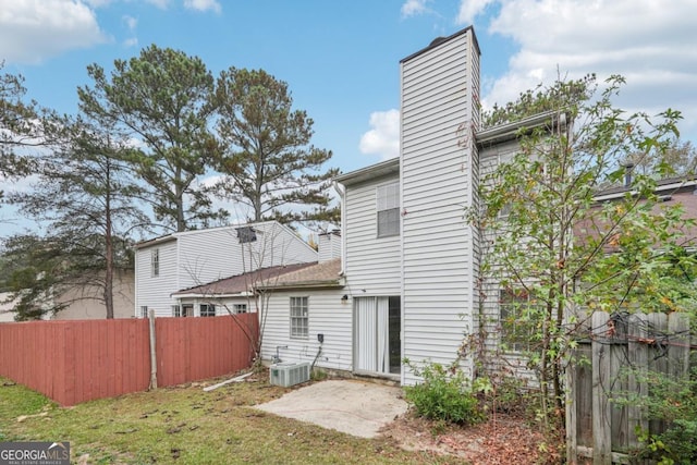 rear view of property featuring central air condition unit, a yard, and a patio