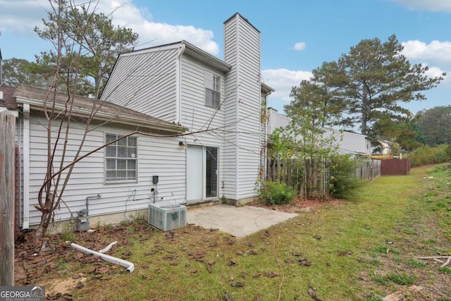 rear view of property with a lawn, central AC, and a patio