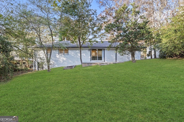 rear view of property with a yard