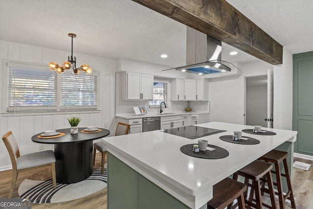 kitchen with decorative light fixtures, light hardwood / wood-style floors, stainless steel dishwasher, sink, and white cabinets