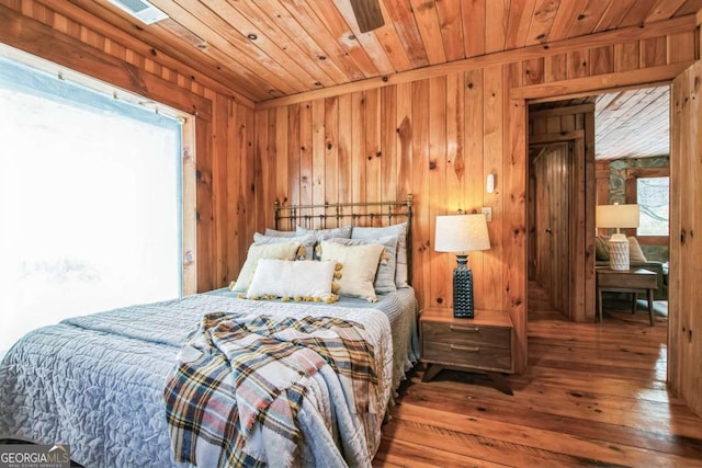 bedroom featuring wooden ceiling, hardwood / wood-style floors, and wooden walls