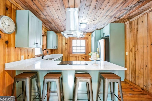 kitchen featuring sink, wood ceiling, stainless steel fridge, and wood walls