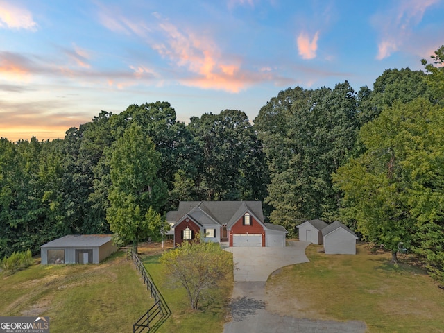 view of front of home with a garage, a lawn, and an outdoor structure