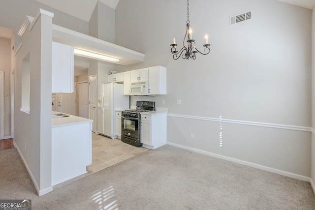 kitchen featuring decorative light fixtures, light colored carpet, a notable chandelier, white appliances, and white cabinets