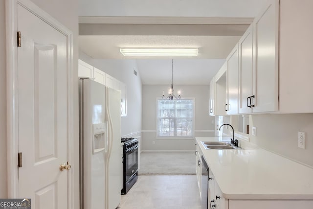 kitchen featuring black range with gas stovetop, sink, white cabinetry, white refrigerator with ice dispenser, and a chandelier