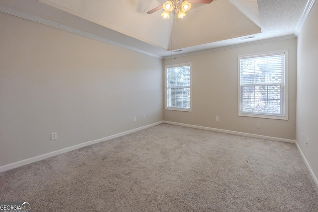 spare room with ceiling fan, a wealth of natural light, a tray ceiling, and ornamental molding