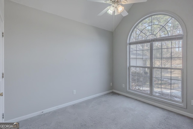 carpeted spare room with ceiling fan and vaulted ceiling