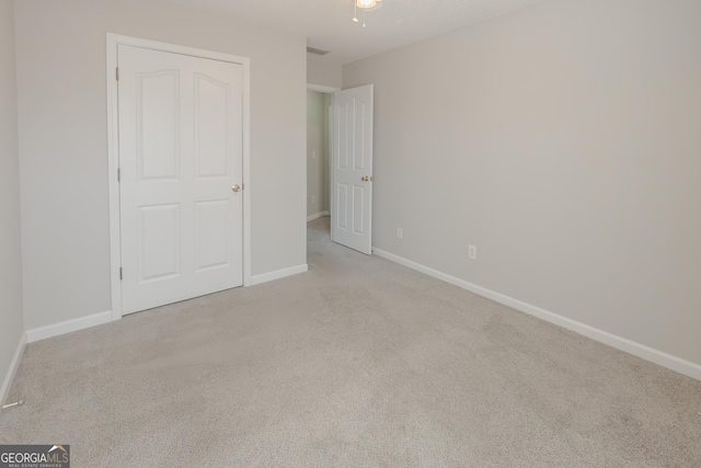 unfurnished bedroom featuring light colored carpet