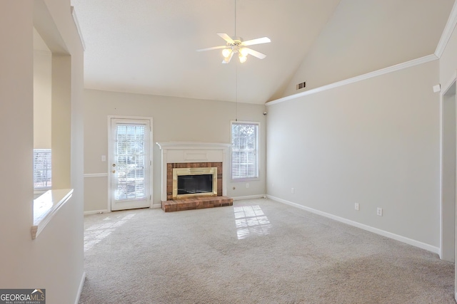 unfurnished living room with ceiling fan, a brick fireplace, light colored carpet, high vaulted ceiling, and ornamental molding