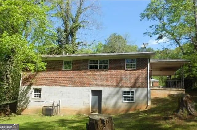 back of property with cooling unit and a yard