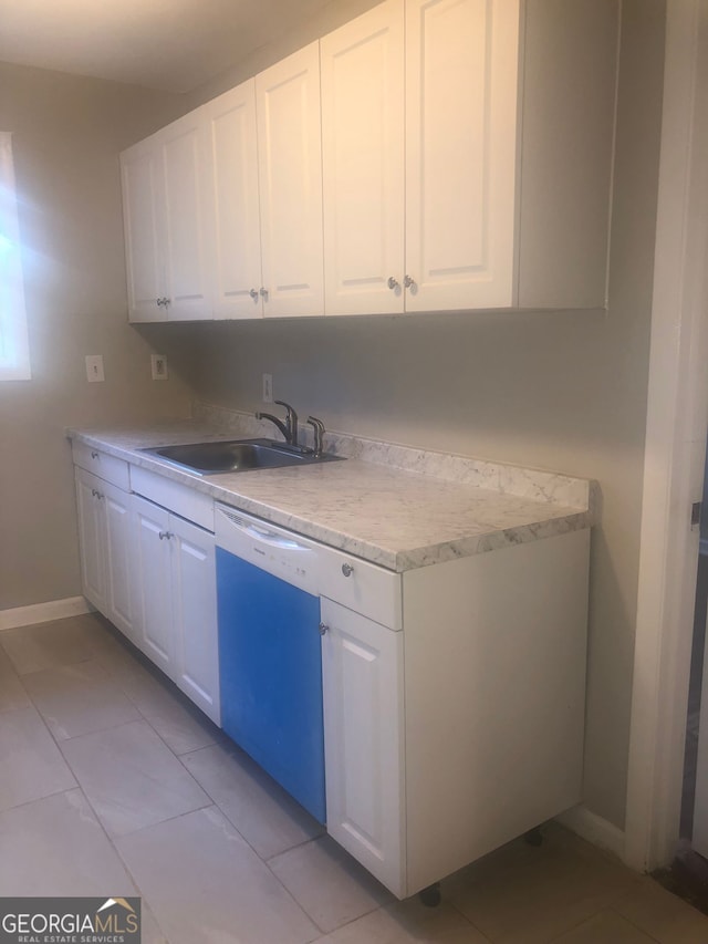 kitchen featuring light tile patterned floors, white cabinetry, dishwasher, and sink