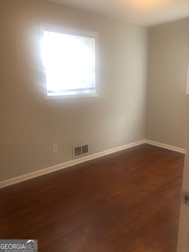 unfurnished room featuring dark hardwood / wood-style flooring