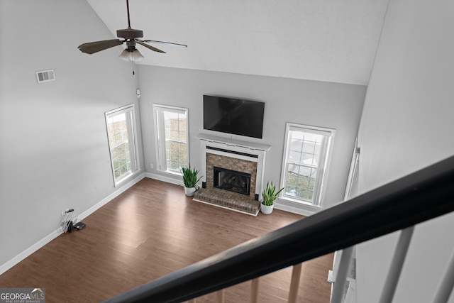 unfurnished living room featuring high vaulted ceiling, a healthy amount of sunlight, and a brick fireplace