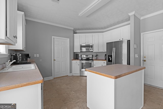 kitchen with stainless steel appliances, a center island, white cabinets, and sink