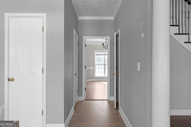 corridor with a textured ceiling and ornamental molding