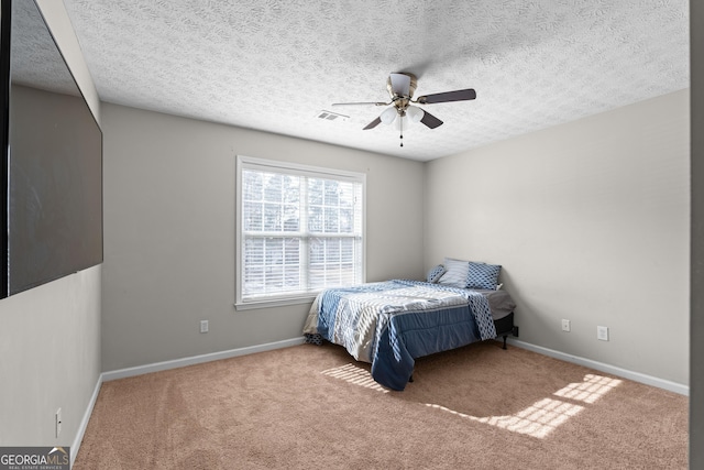 bedroom with a textured ceiling, ceiling fan, and carpet