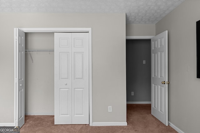 unfurnished bedroom with a closet, a textured ceiling, and carpet flooring