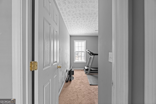 exercise room featuring carpet floors and a textured ceiling