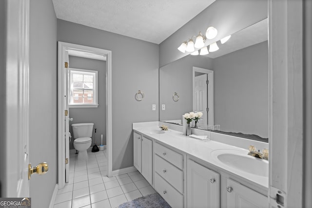 bathroom with a textured ceiling, tile patterned floors, vanity, and toilet