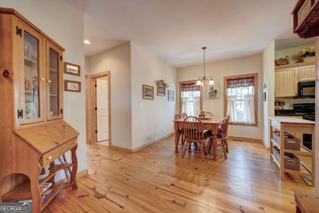 dining space featuring light hardwood / wood-style floors and an inviting chandelier