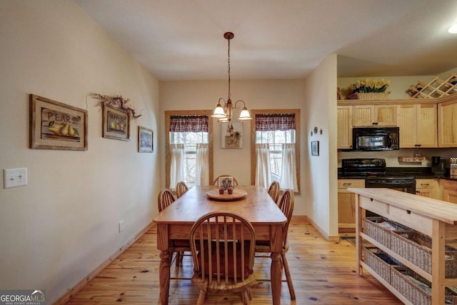 dining space featuring light hardwood / wood-style flooring and a notable chandelier