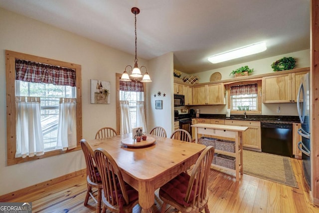 dining room with sink, an inviting chandelier, and light hardwood / wood-style flooring