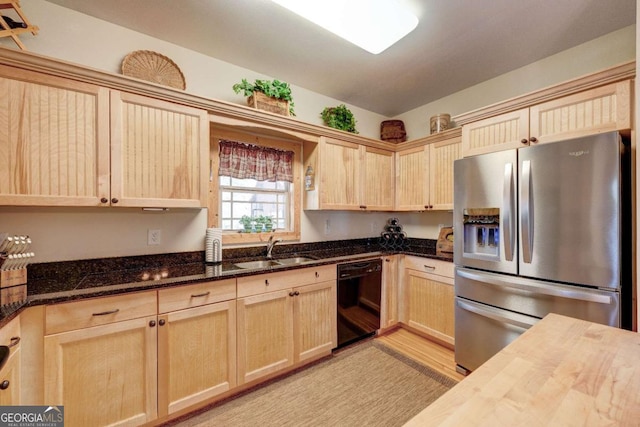 kitchen featuring stainless steel refrigerator with ice dispenser, black dishwasher, butcher block counters, light brown cabinetry, and sink