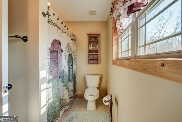 bathroom featuring toilet and tile patterned flooring