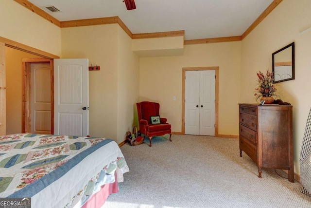 carpeted bedroom featuring ceiling fan, a closet, and crown molding