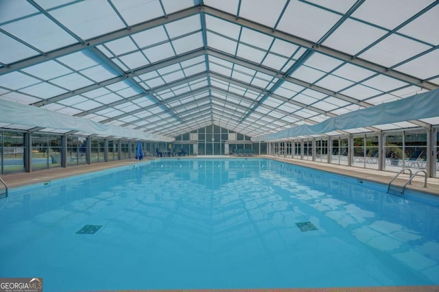 view of swimming pool featuring glass enclosure