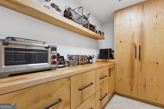 kitchen with light tile patterned flooring and wood counters