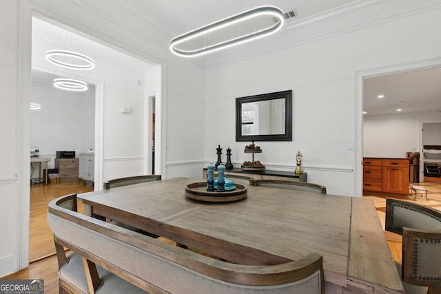 dining area featuring light hardwood / wood-style flooring and ornamental molding