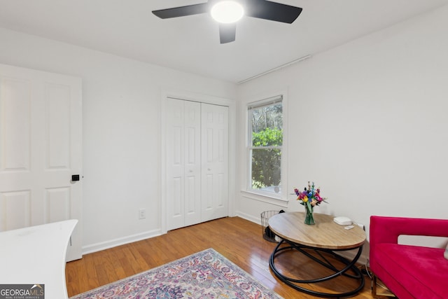 living area with hardwood / wood-style flooring and ceiling fan