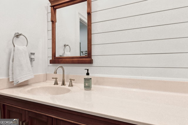 bathroom featuring wood walls and vanity