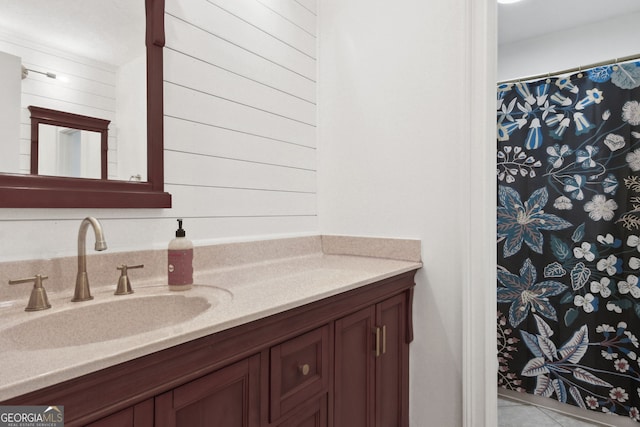 bathroom with tile patterned flooring, wood walls, and vanity